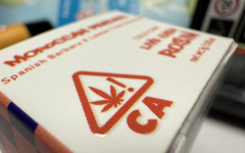 Close up shot of a cannabis concentrate box showing the California cannabis compliance logo
