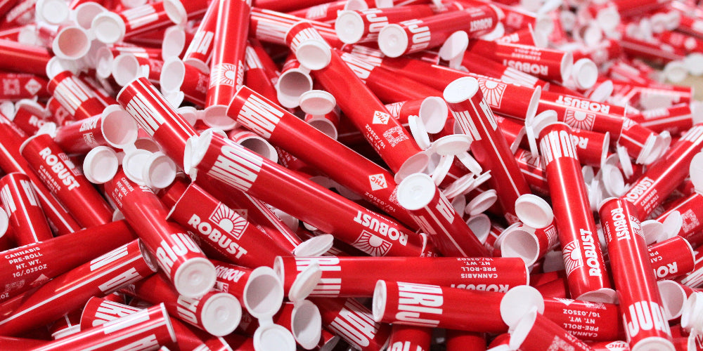 Bulk red child resistant in mold labeled pre-roll tubes with pop-top lids used for cannabis pre-roll packaging.