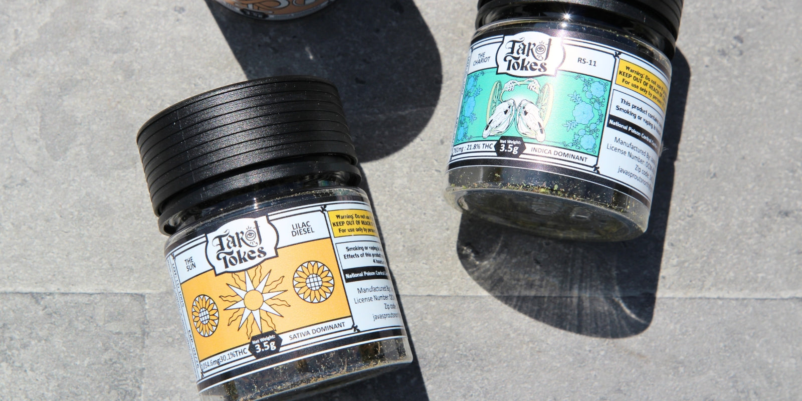 Custom flower jars with black child resistant lids and illustrated labels, shown on a stone surface to highlight branded cannabis flower packaging design.